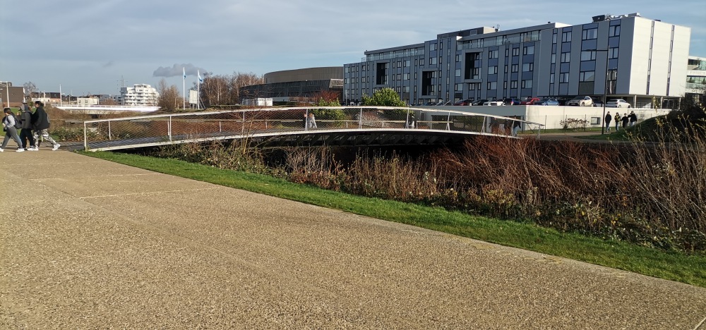 Passerelle piétonne enjambant la rivière Haine.